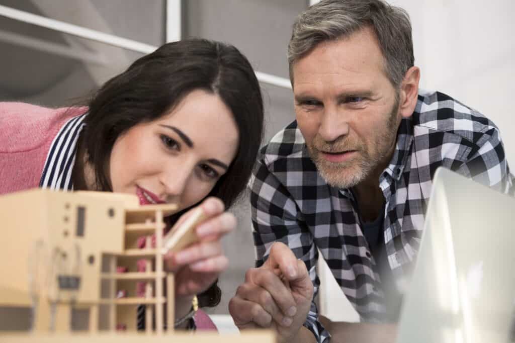 Colleagues examining architectural model in office